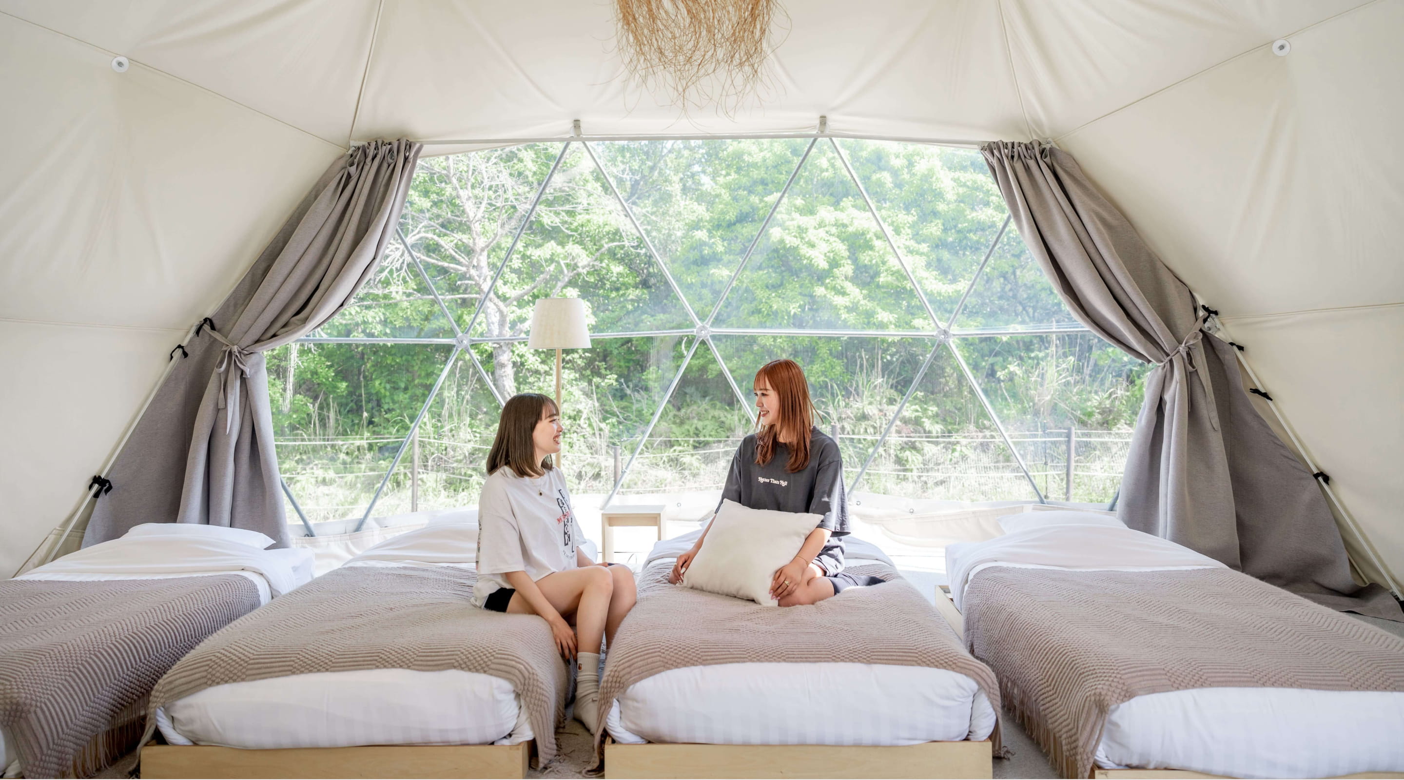 Photo of women relaxing on beds in a tent