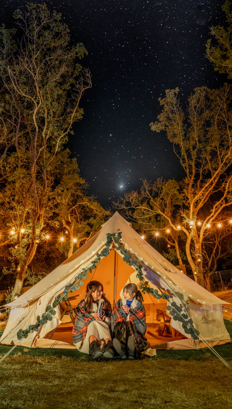 Photo of a woman enjoying illuminations in a tent